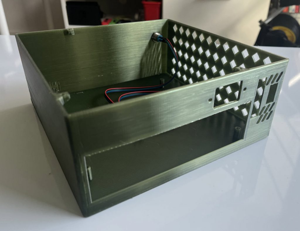 Back of the Mini PC Case with cutouts for the motherboard IO, power, and GPU